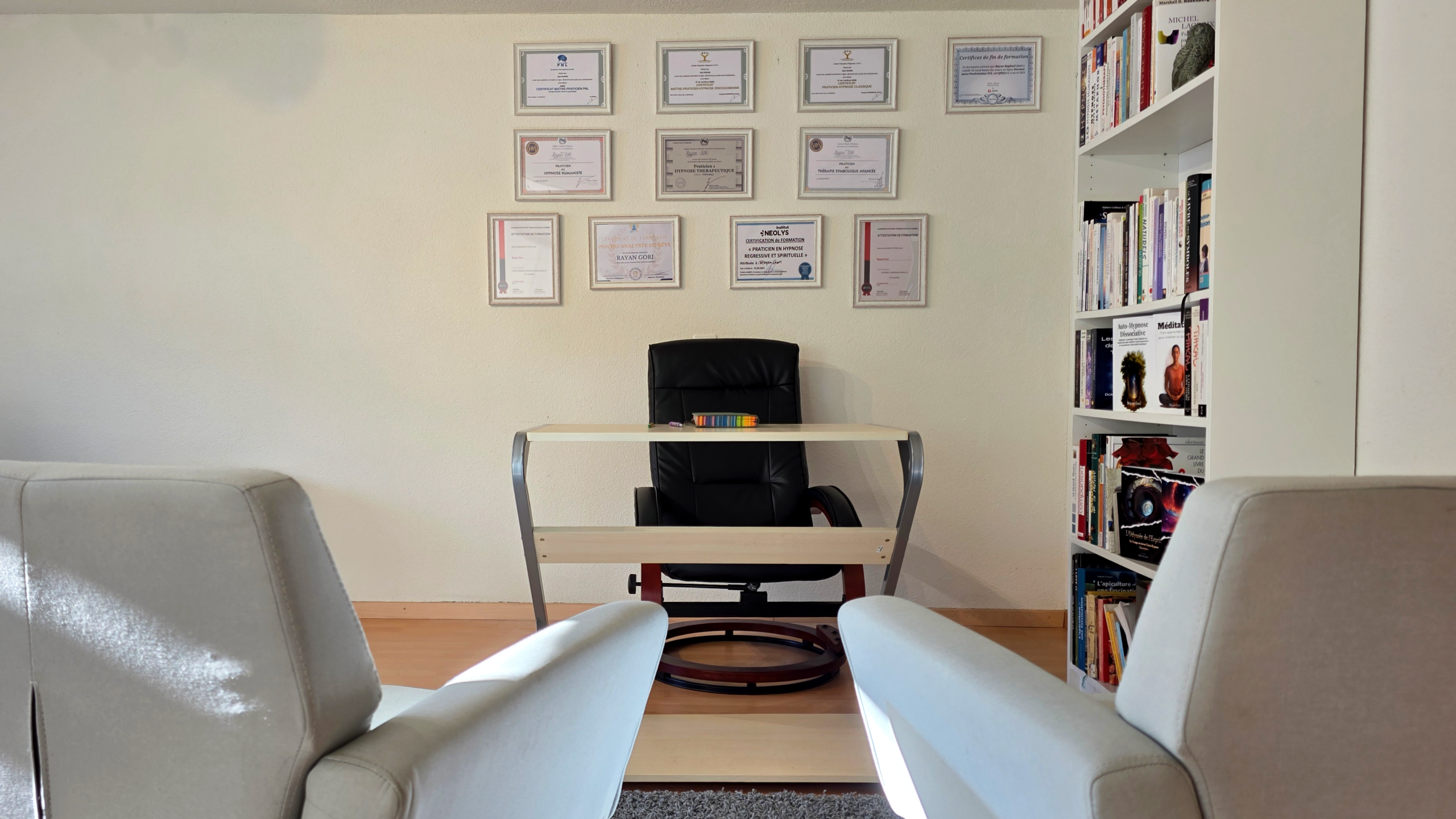 Espace d’échange et de dialogue du cabinet Hypno-Alchimiste à Sonvilier : fauteuils et bureau dans un cadre sobre et rassurant